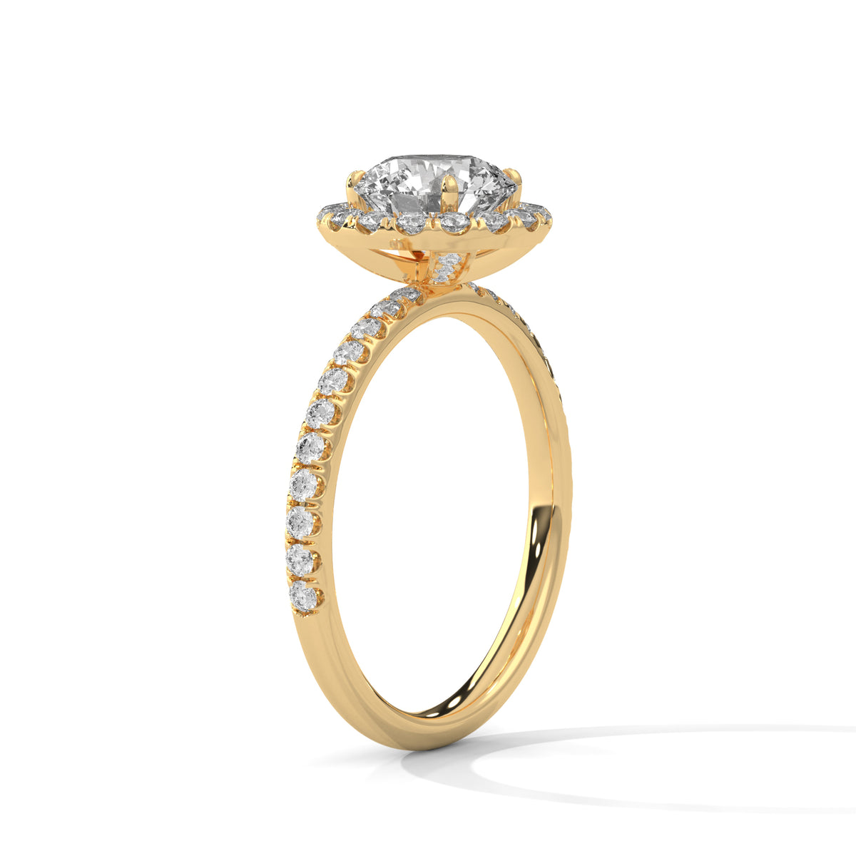 Angled side view of a round cut diamond halo engagement ring in yellow gold with a pavé diamond band and raised halo setting.