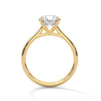 Side profile of a round cut diamond solitaire engagement ring in yellow gold with a raised four-prong setting and open gallery.