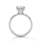 Side view of a round cut diamond pave engagement ring in white gold with a raised prong setting on a white background