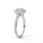 Angled side view of a round cut diamond halo engagement ring in white gold with a pave diamond band and raised setting.
