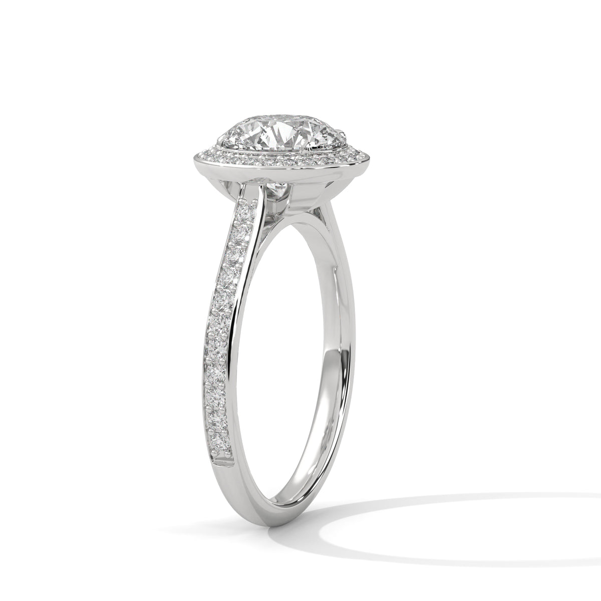 Angled side view of a round cut diamond halo engagement ring in white gold with a pave diamond band and raised setting.