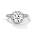 Round cut diamond halo engagement ring in white gold with a pave diamond band, shown in a front product view.