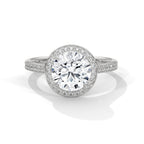 Round cut diamond halo engagement ring in white gold with a pave diamond band, shown in a front product view.
