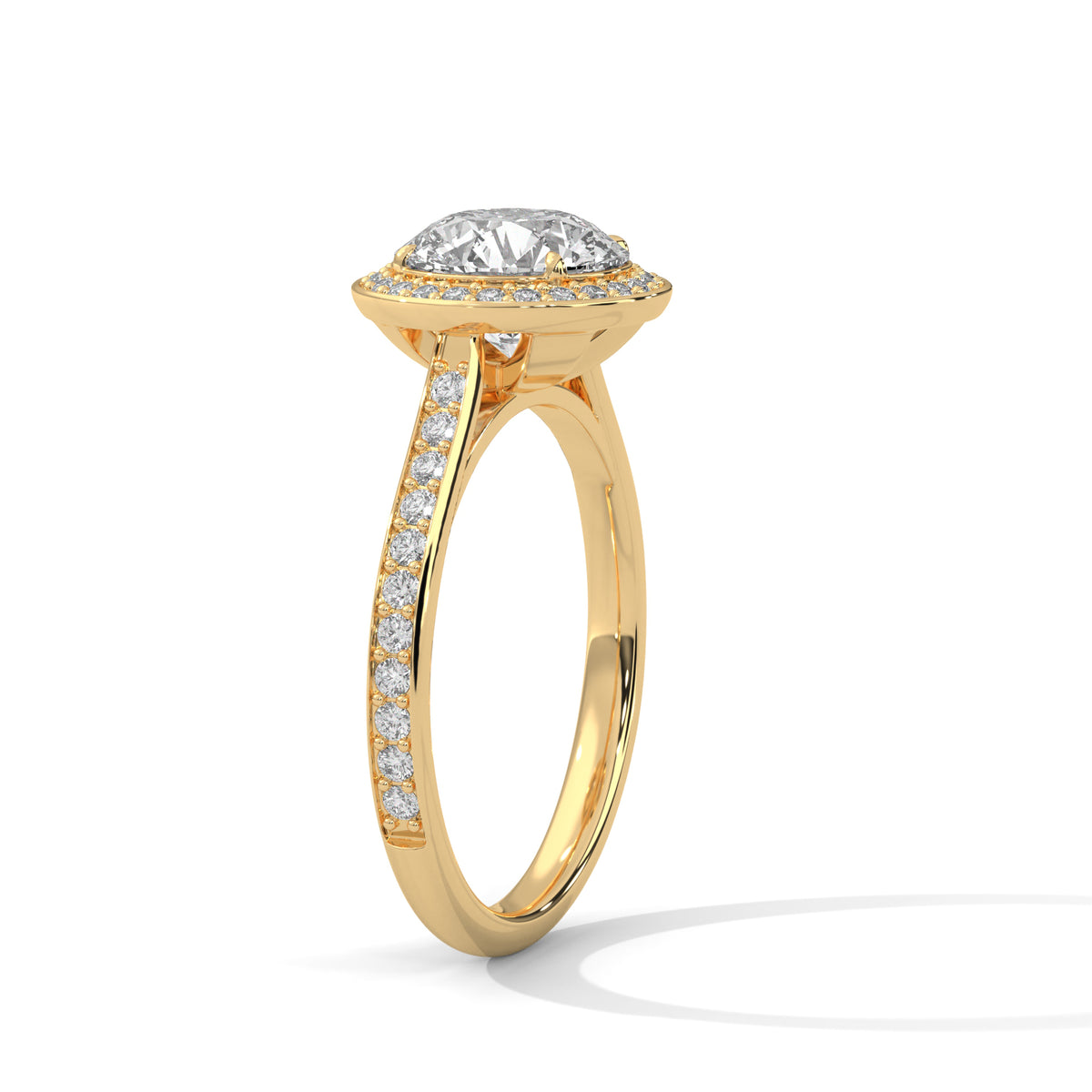 Angled side view of a round cut diamond halo engagement ring in yellow gold with a pavé diamond band and raised setting.