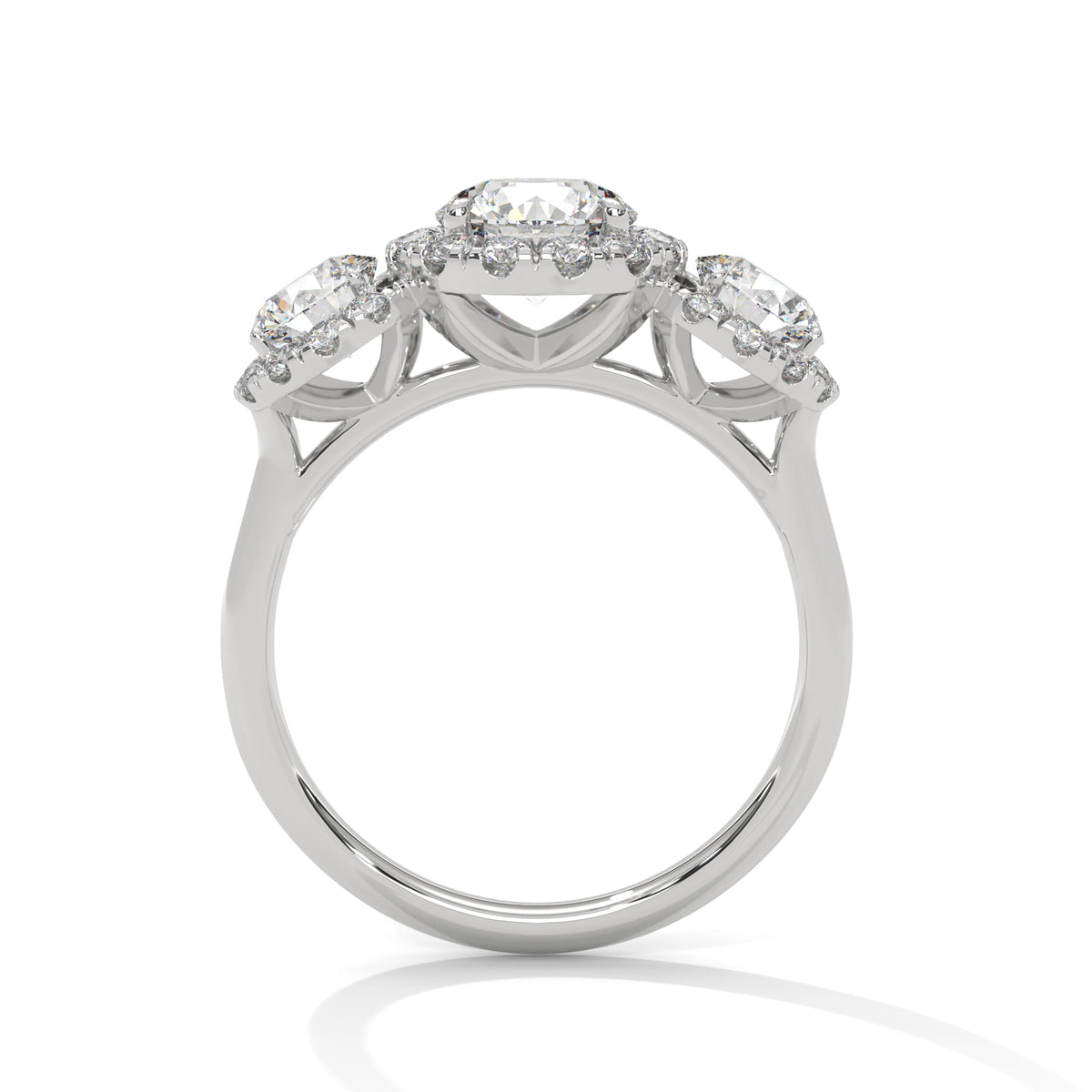 Side profile of a three-stone round cut diamond halo engagement ring in white gold with raised gallery settings.