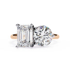 Diamond ring with emerald-cut and round-cut diamonds on a white background
