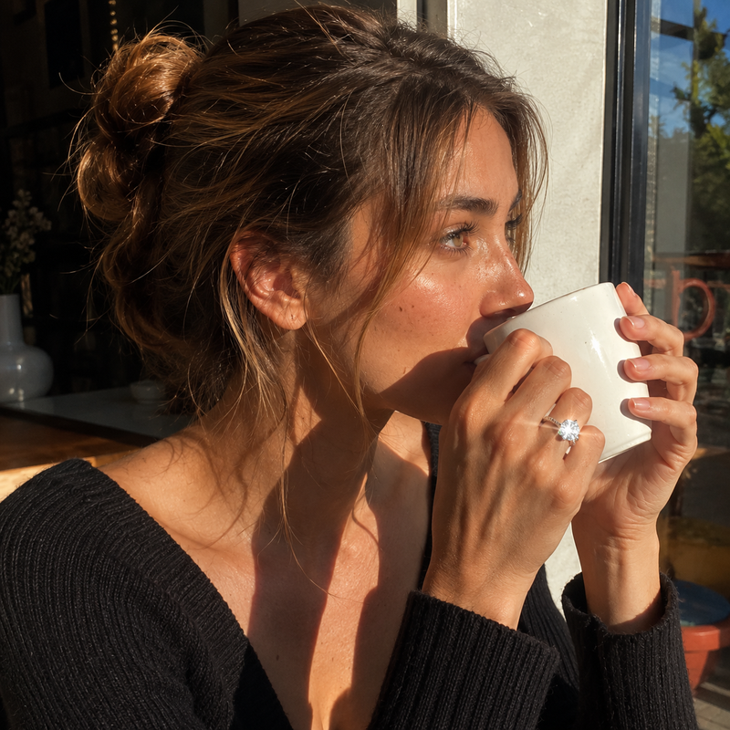 Woman drinking from a white cup outdoors
